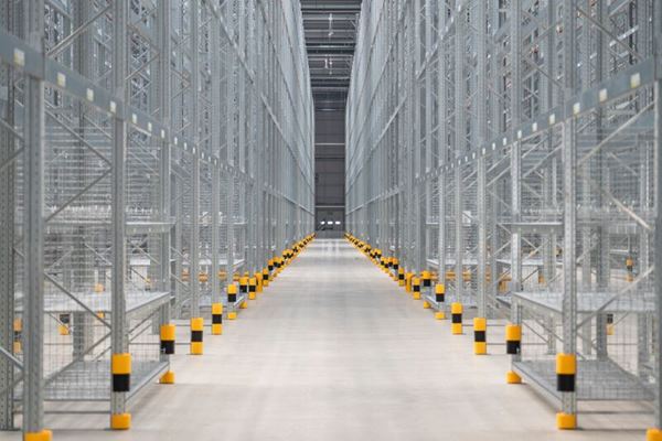 Industrial warehouse with P90 pallet racking system, multiple rack aisles storing palletised goods with full-height steel structures